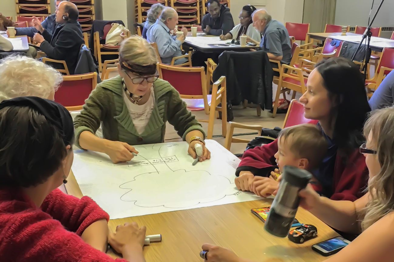 Indigenous and non-indigenous Canadians work together on a large poster board image